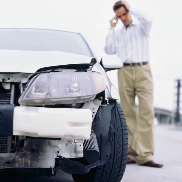 An image showing a driver who's rental car was involved in an accident, actively calling auto accident lawyers in Alabama.